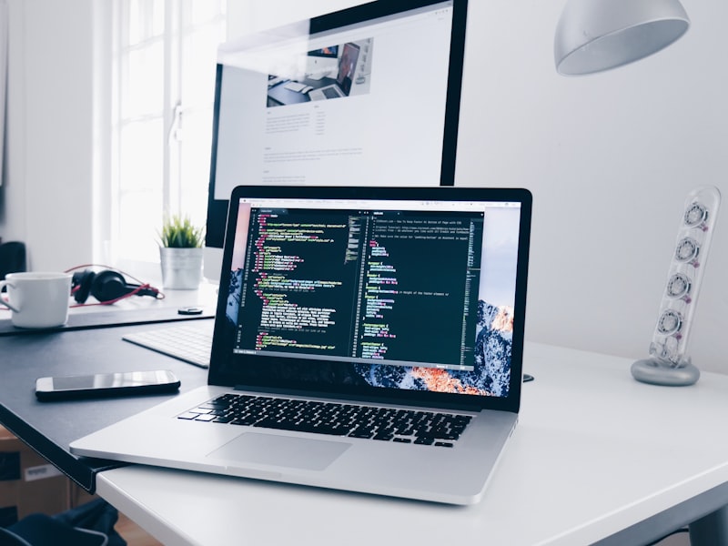 Modern workspace with code editor and laptop